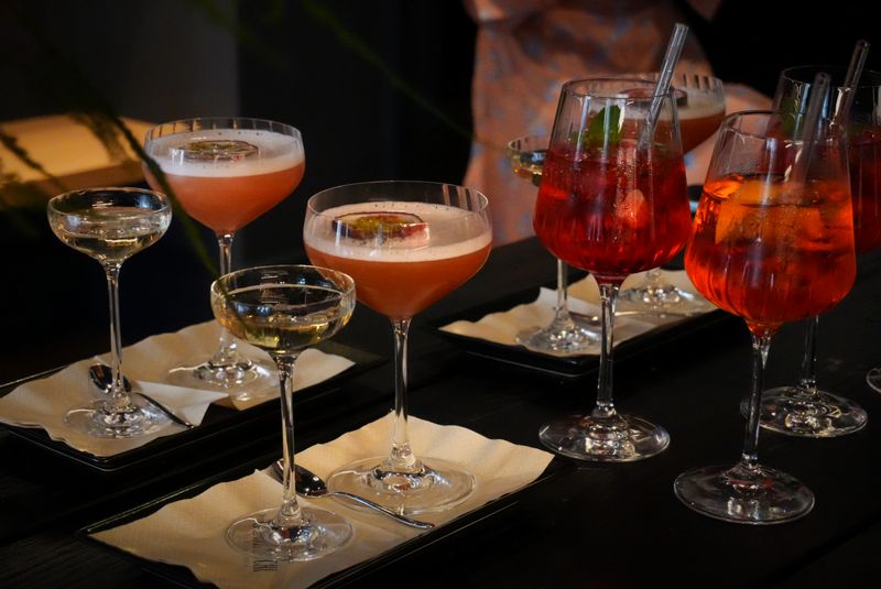 Gläser mit Aperitif auf einem dunklen Holztisch in der Blumengalerie